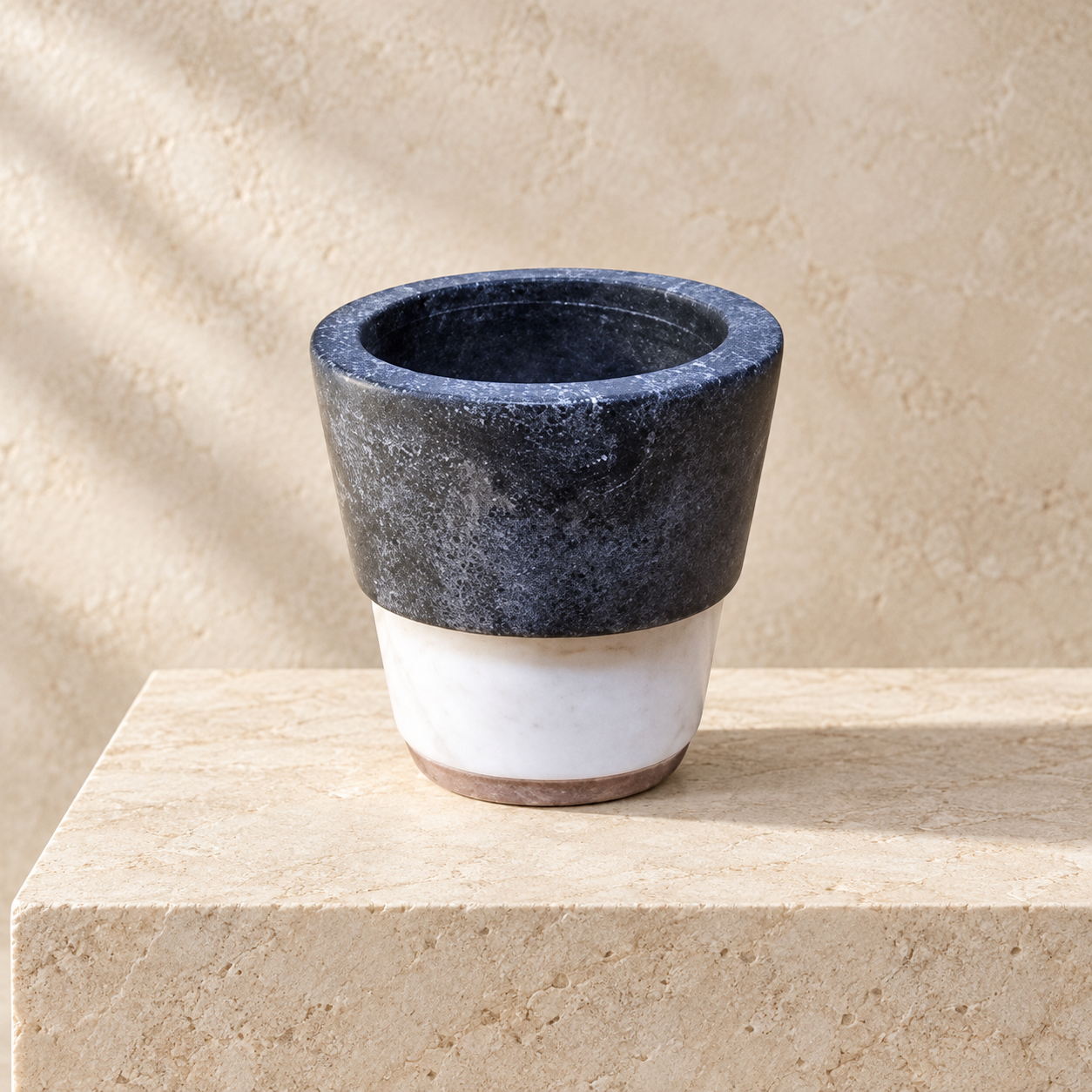 Two-tone marble tumbler on a warm stone surface